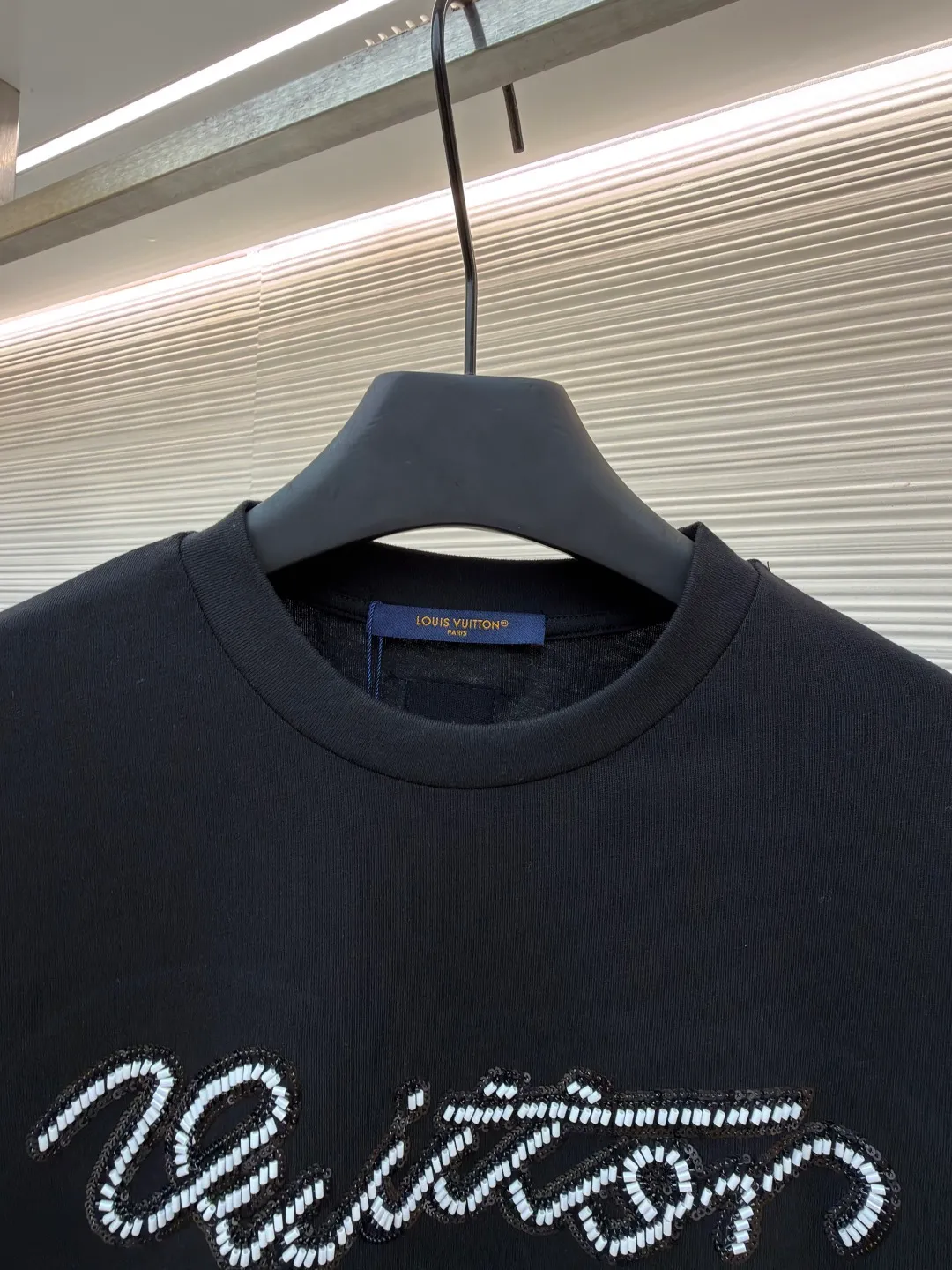LOUIS VUITTON round neck beaded embroidered short-sleeved T-shirt ●Original version: purchased and developed by 11353 ●Item number: 1681544-A15 ●Material: cotton fabric ●Technology: beading ●Color: black ●Version: fitted version ●Weight: about 310 grams ●Size: XS-S-M-L ●Description: This black T-shirt is made of 100% High-quality cotton fabric, soft to the touch, skin-friendly and breathable. The round neck design fits the neck line and is neatly cut, presenting a classic and simple silhouette. The word "Vuitton" on the chest is the highlight of the entire work: using hand-beading technology, each tiny bead is carefully arranged by craftsmen and fixed on the fabric at precise spacing and angles, forming smooth curves and a full three-dimensional sense. This process not only gives the letters a delicate luster, but also adds to the overall texture and high-end feel. The stitching on the body is even and neat, about 12 stitches per inch, ensuring a solid structure and not easily deformed. The hem and cuffs are smooth and neat, and the edges are clean and neat, reflecting the exquisite craftsmanship of clothing. The overall style presents a low-key luxury style, which is not only suitable for daily wear, but also shows quality and taste in the details. The overall wiring is straight and delicate, the fabric is comfortable and soft, and the color is consistent without color difference. It can be matched with the same style to create a fashionable look and control various occasions. Customized accessories, complete with three standards, same style for men and women!